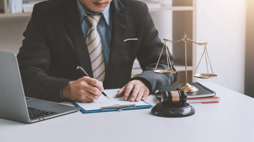A truck accident lawyer at his desk signing legal documents for a client.