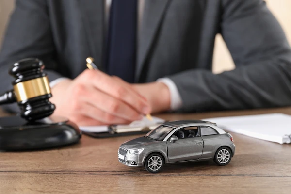 An Atlanta car accident lawyer works at a desk with a model car.