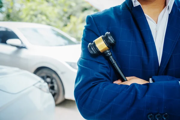 An Atlanta car accident lawyer from H Groves Law stands near a vehicle.